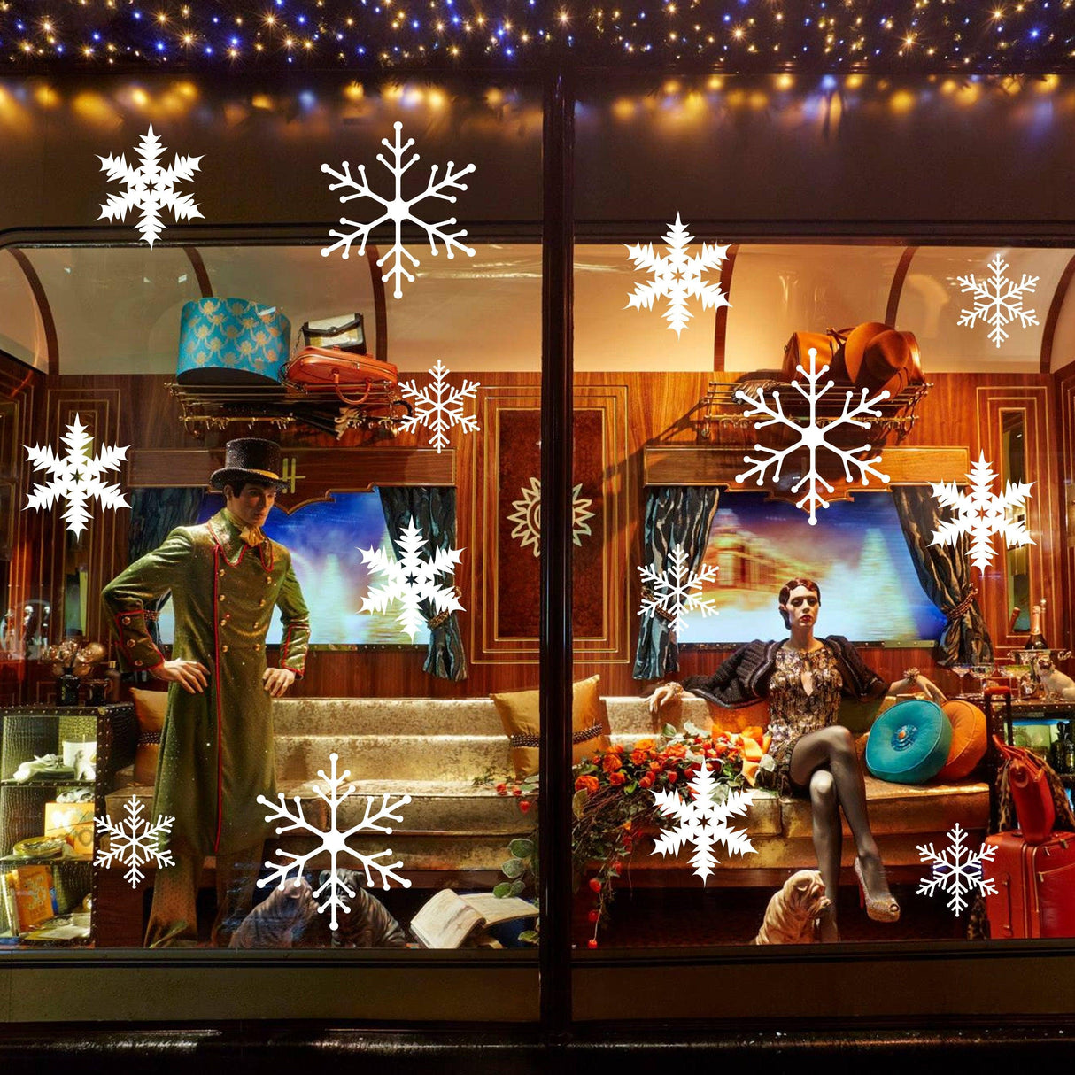 Winter window display featuring snowflake decals and stylish mannequins, creating a magical holiday atmosphere.