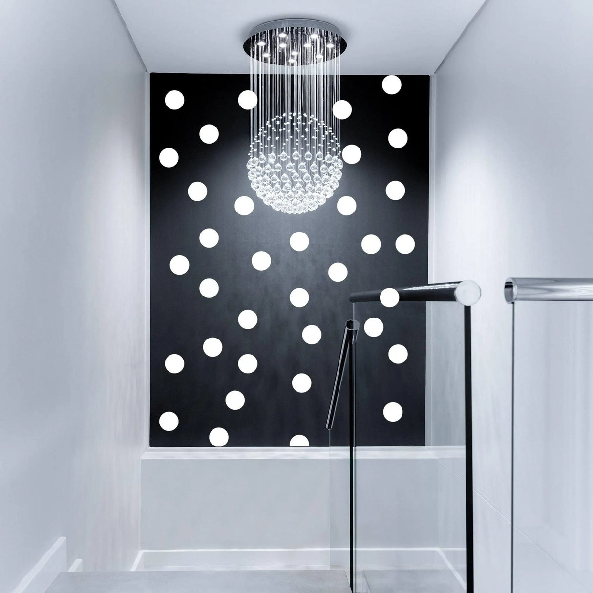 Stylish hallway featuring black wall with white round circle dot stickers and modern chandelier lighting.