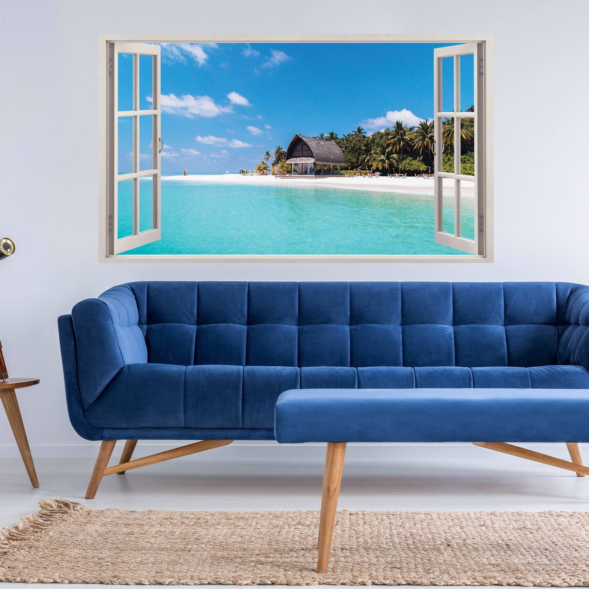 Tropical paradise window sticker showcasing a beach view with a blue couch and natural decor in a modern living room.