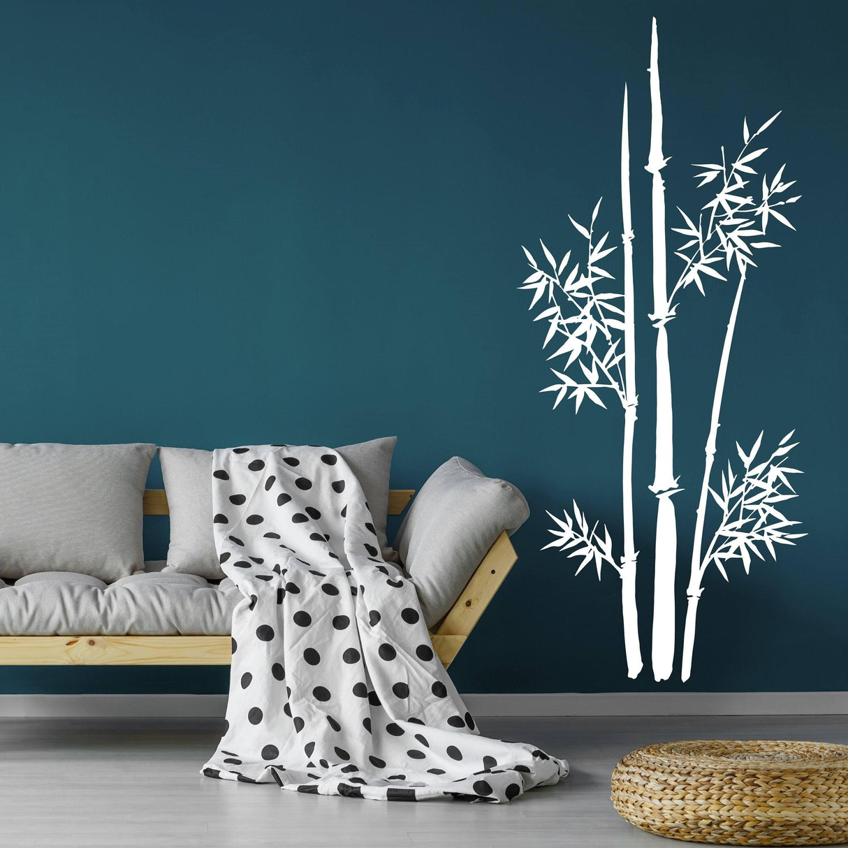 Bamboo wall art vinyl decal on a teal wall above a modern sofa with polka dot throw blanket.