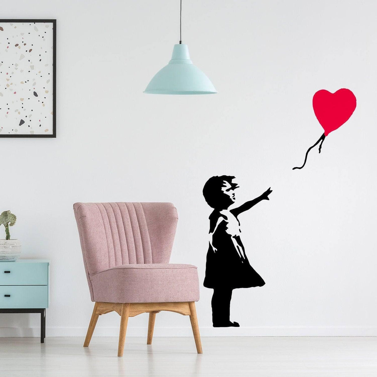 Vinyl wall decal of a girl reaching for a heart balloon, bringing whimsy and hope to any room decor.