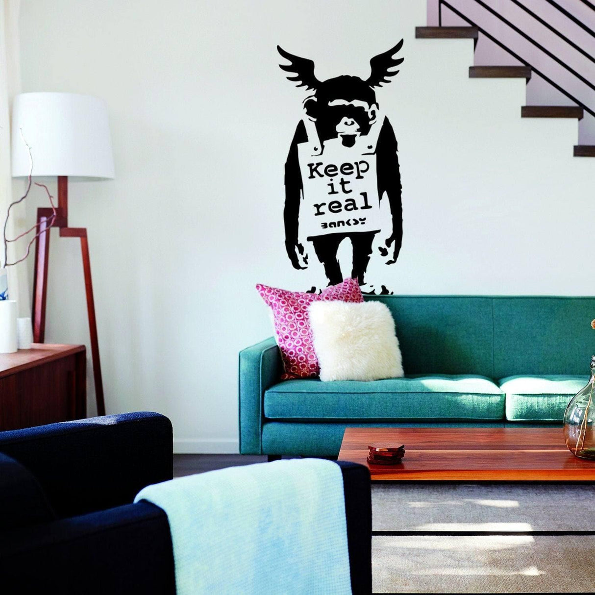 Banksy monkey graffiti decal on living room wall, featuring 'Keep it real' text, adding urban style to the space.