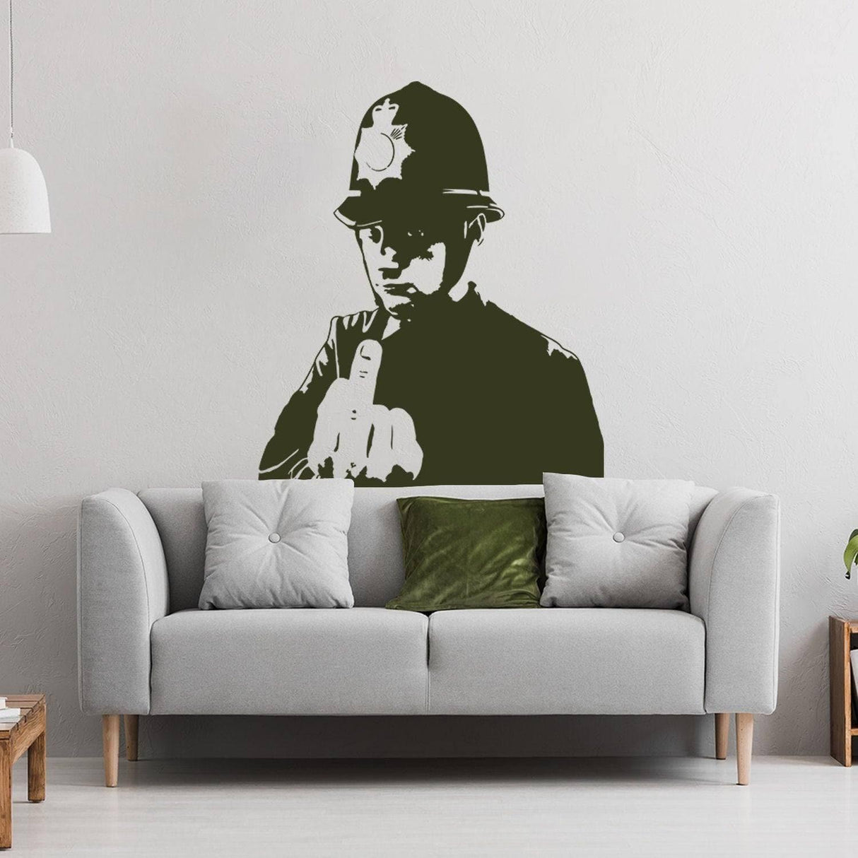 Urban Expression Scotland Yard cop wall decal displayed above a modern grey sofa in a stylish living room.