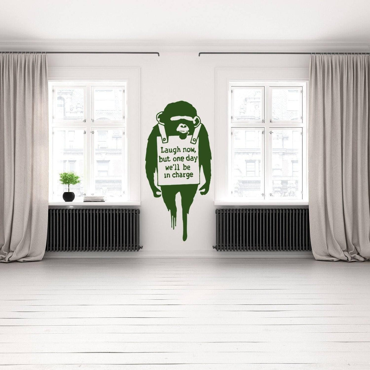 Banksy inspired monkey wall art decal in modern living room with quote 'Laugh now, but one day we'll be in charge'.