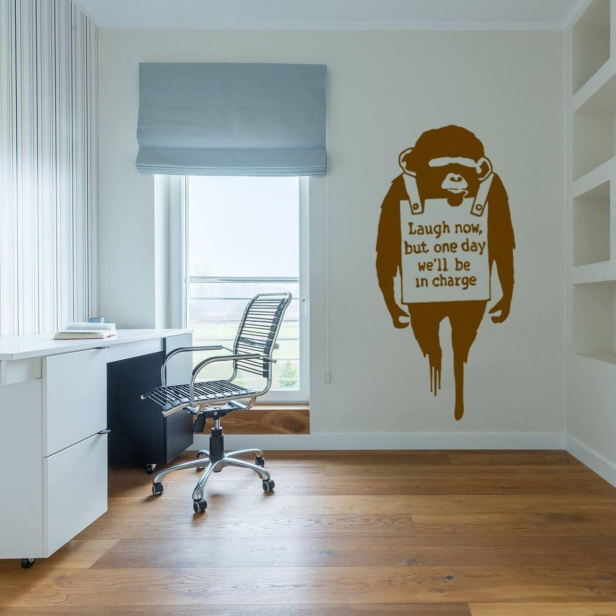 Banksy inspired monkey wall decal in modern office setting with the phrase 'Laugh now, but one day we'll be in charge'.