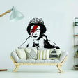 Regal Vinyl Sticker featuring Banksy-inspired design of Queen with David Bowie makeup on a white wall above a modern couch.