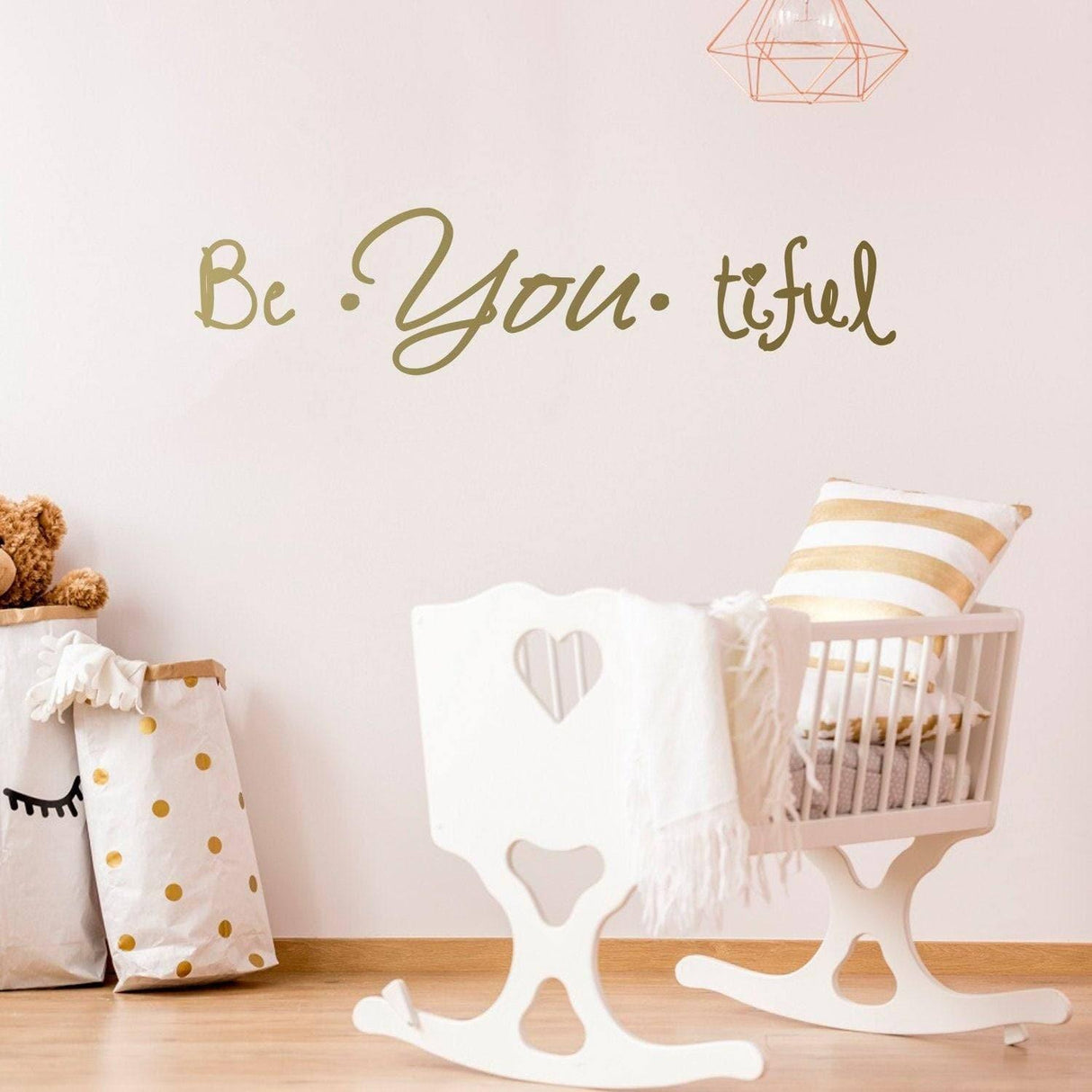 Inspire Beauty vinyl wall decal saying 'Be You tiful' on a nursery wall with a rocking chair and teddy bear.