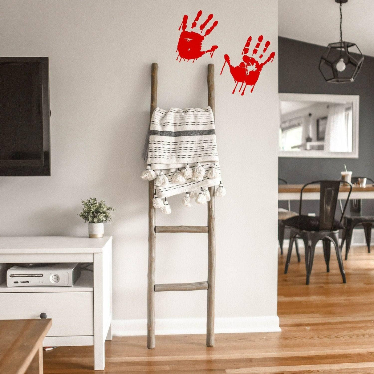 Spooky red handprint vinyl decal on a wall above a wooden ladder with a blanket.