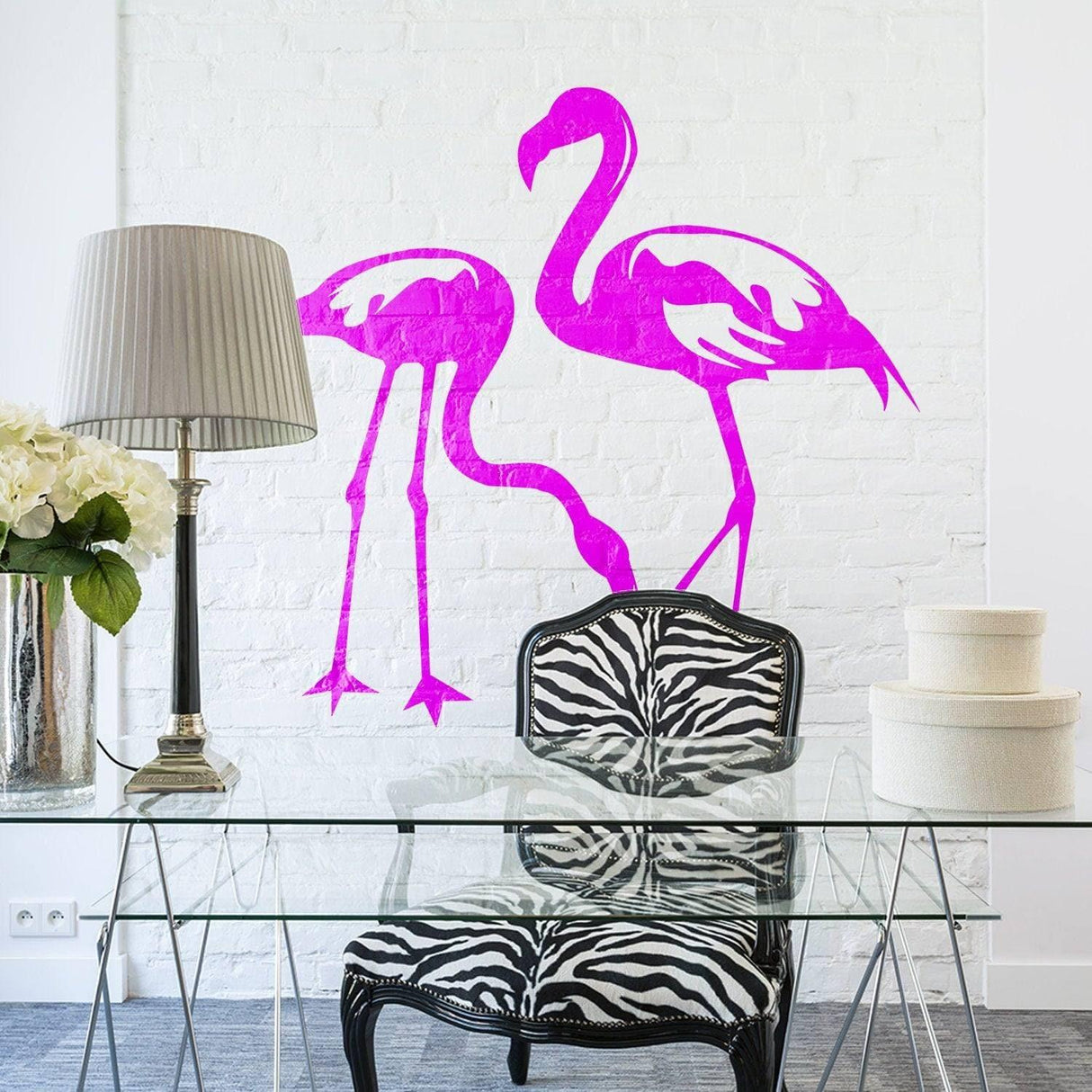 Pink flamingo wall decal on a white brick wall in a modern decor setting with a glass table and zebra chair.