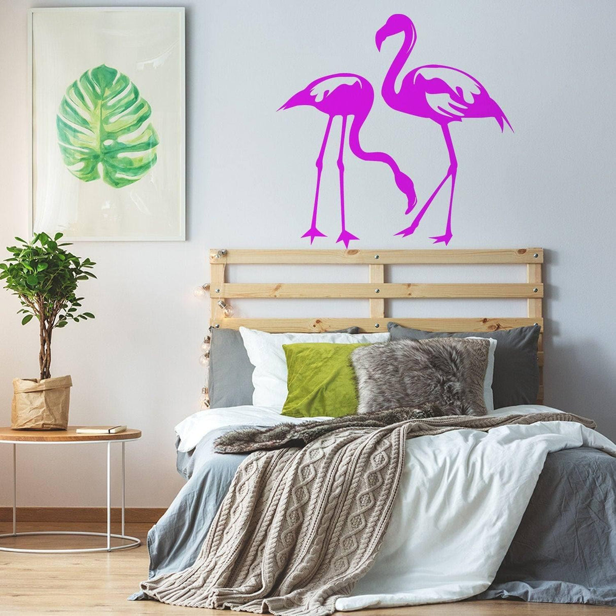 Pink flamingo wall decals above bed in a modern bedroom with tropical decor.