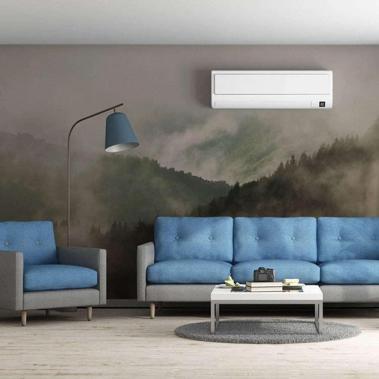 Elegant living room featuring Misty Pine Hill wallpaper mural with foggy forest design, blue couch, and modern lamp.