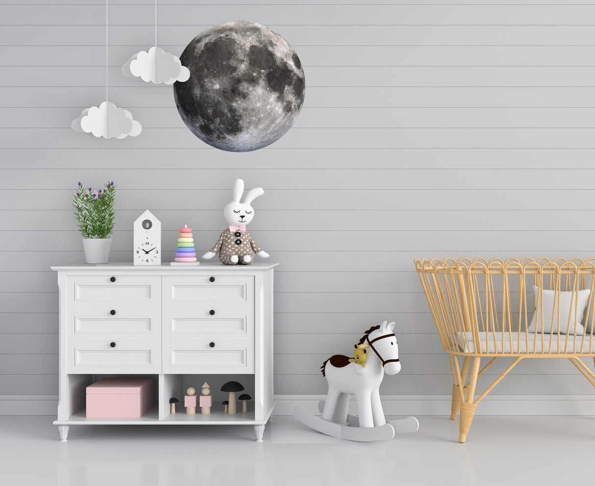 Stylish nursery featuring a large moon wall sticker and cute decor, creating a celestial theme for kids' rooms.