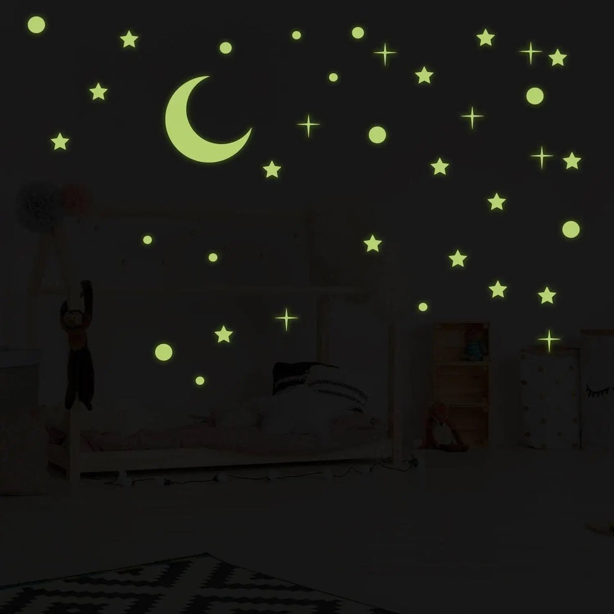 Glow in the dark star stickers and moon decals illuminating a child's bedroom ceiling.