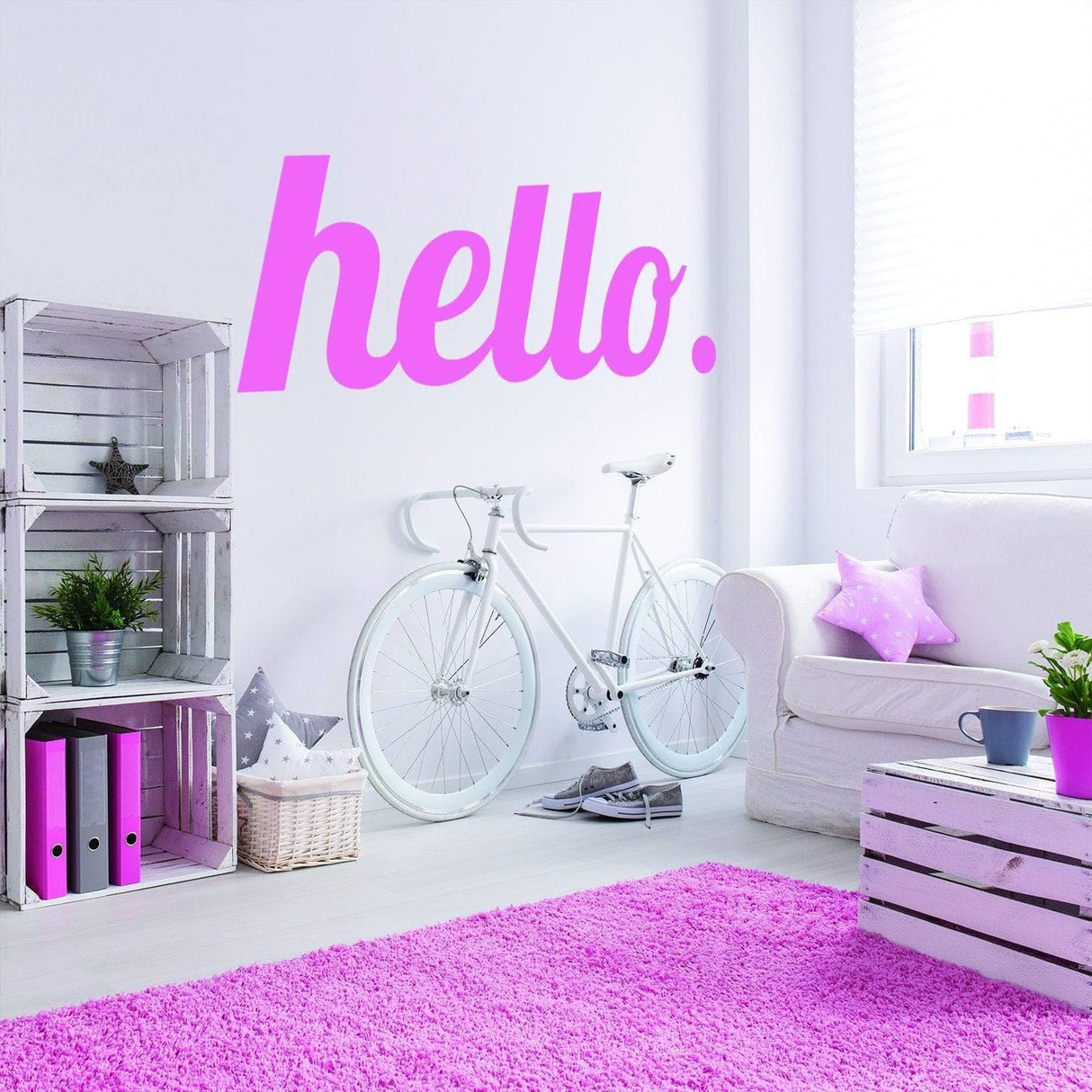 Colorful wall decal saying 'hello.' in a stylish living room with bicycle and decorative shelves.