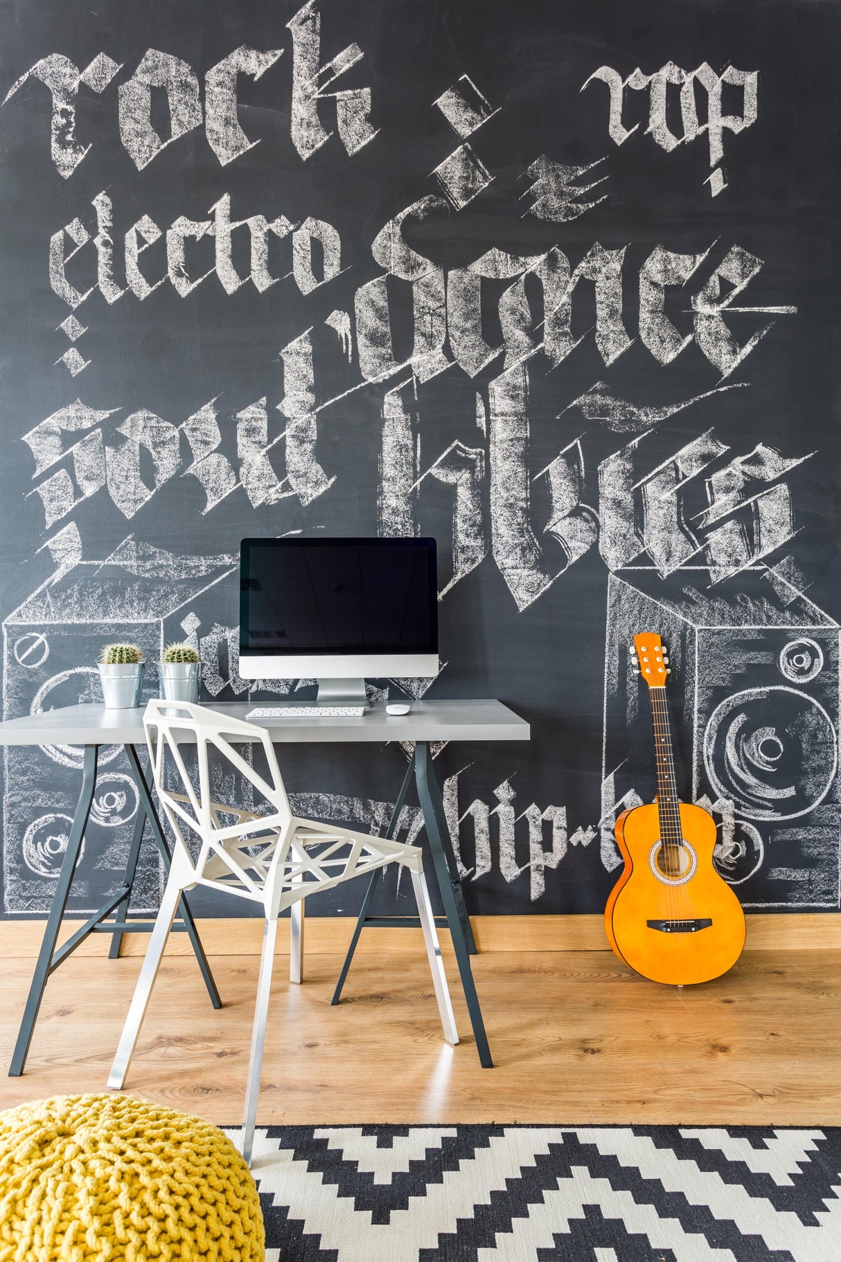 Stylish workspace featuring a black chalkboard wall with music-themed chalk art and a computer desk setup.