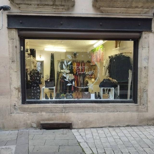 Storefront display of a clothing boutique featuring stylish apparel and accessories in the window.