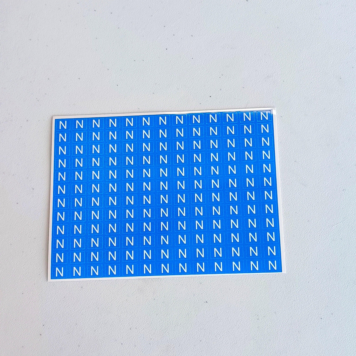 Sheet of blue neutral marking stickers featuring repeated 'N' for electrical component labeling.