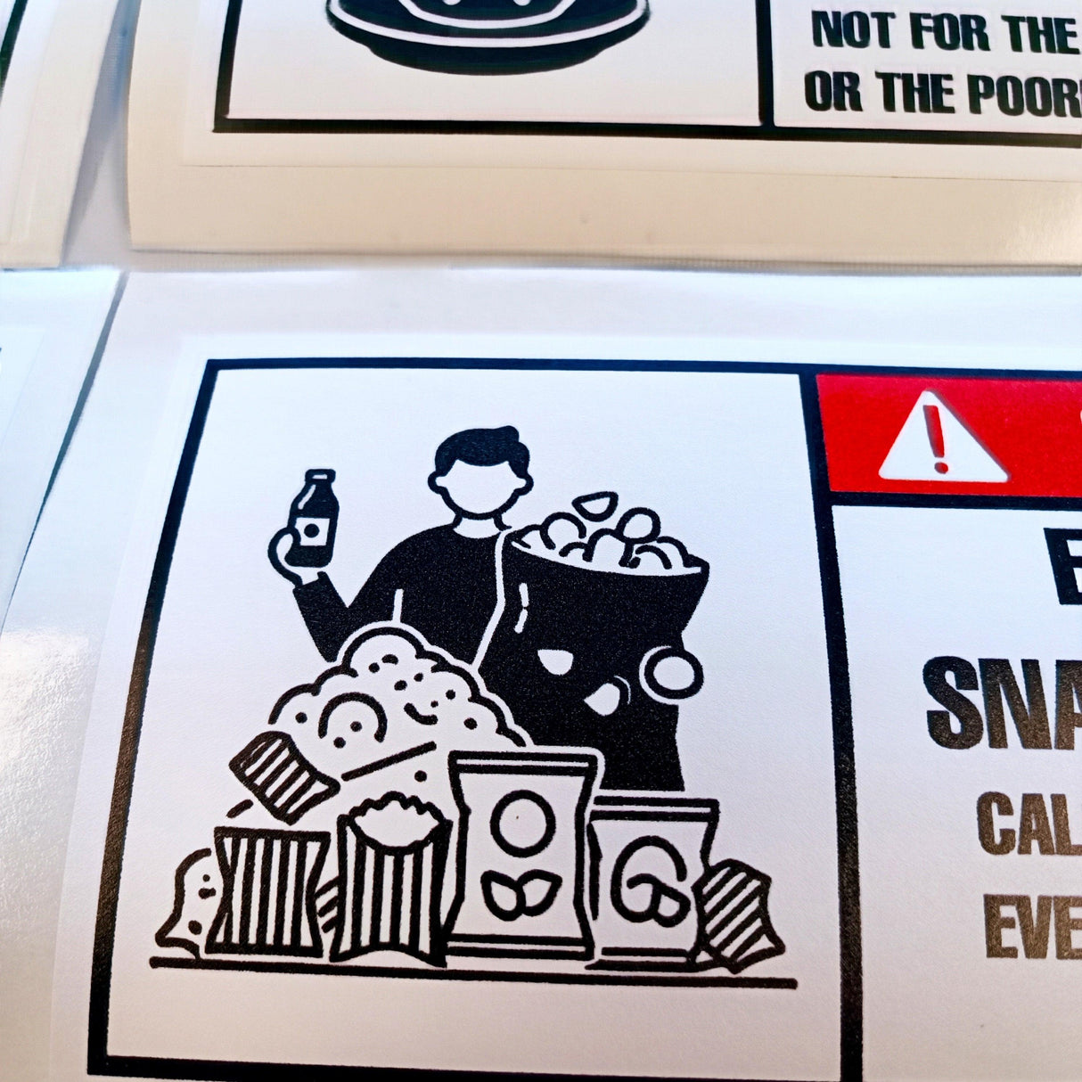 Humorous danger warning sticker featuring a person holding snacks and a drink, perfect for kitchens and offices.
