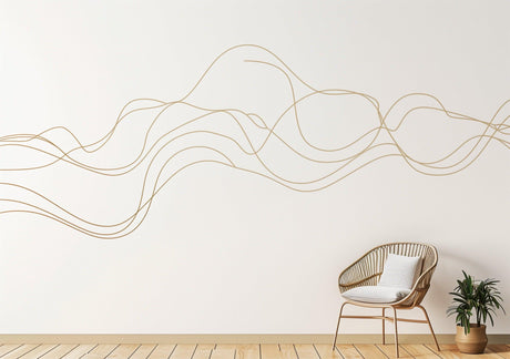 Elegant line art wall sticker in gold, adding a modern touch to a minimalist room with chair and plant.