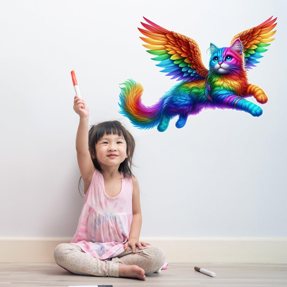 Vibrant rainbow flying cat wall sticker above a smiling girl playing with a marker in her colorful room.