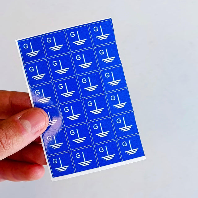 Blue grounding symbol stickers in a square shape, ideal for marking electrical components and ensuring safety.