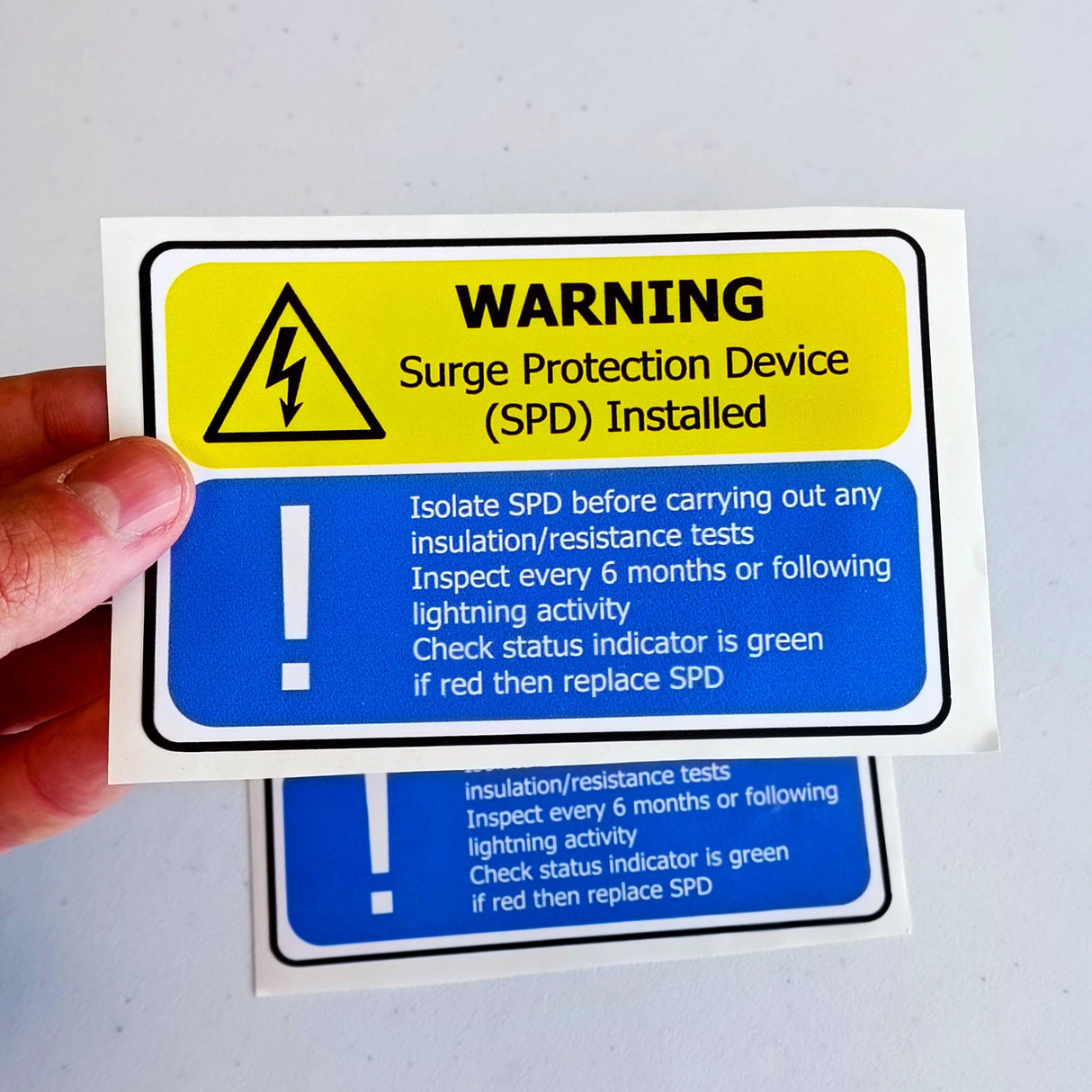 Close-up of a Surge Protection Device (SPD) warning label with safety instructions for electricians.
