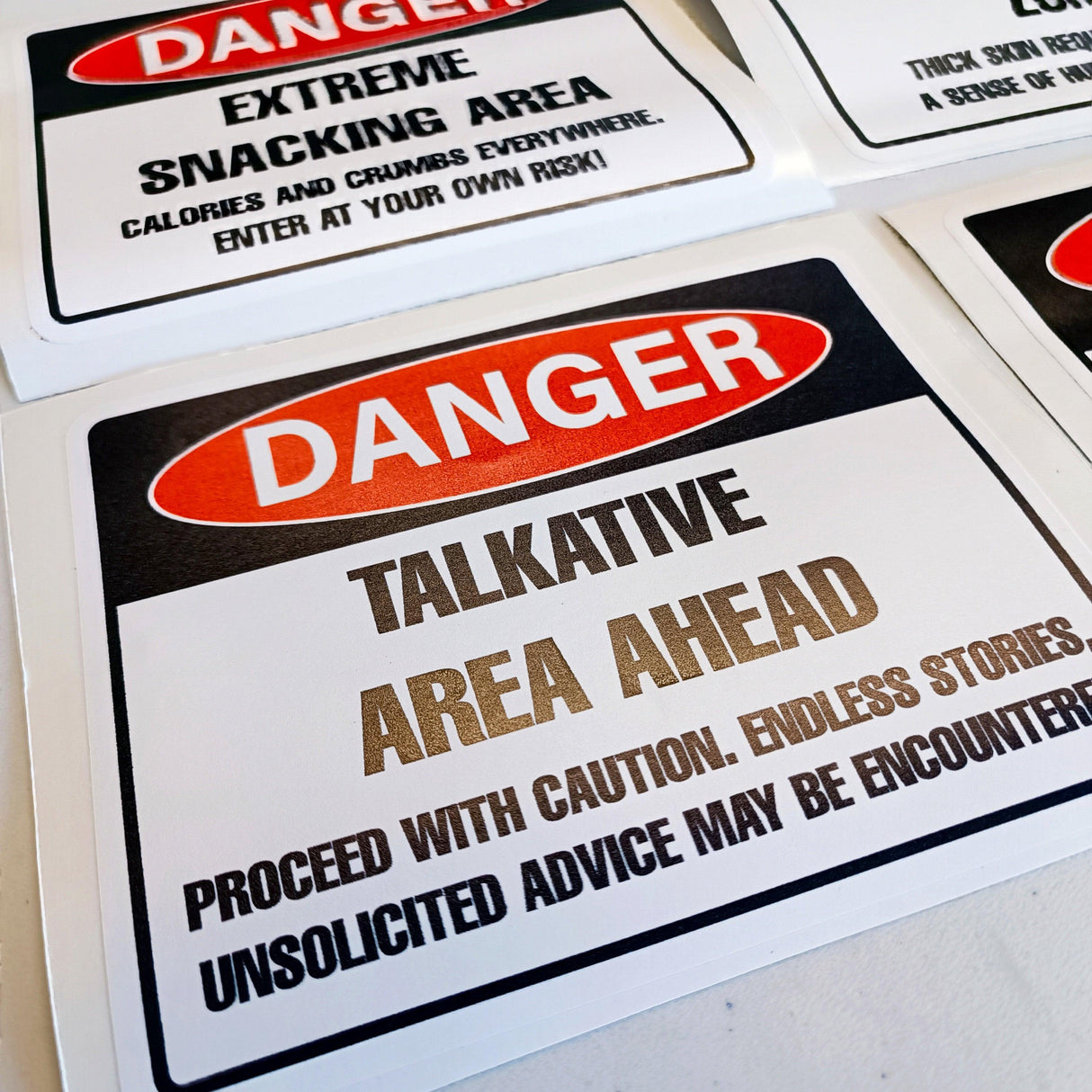 Humorous danger warning label decal for talkative area, featuring bold text and playful design ideal for office or kitchen.