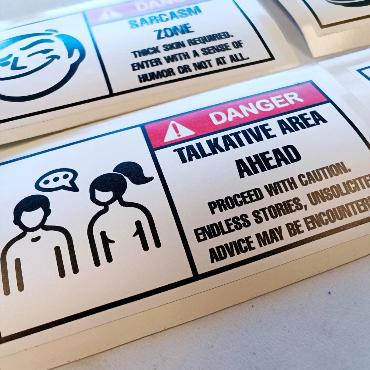 Humorous Danger Warning Label sticker featuring 'Talkative Area Ahead' sign with playful graphics.