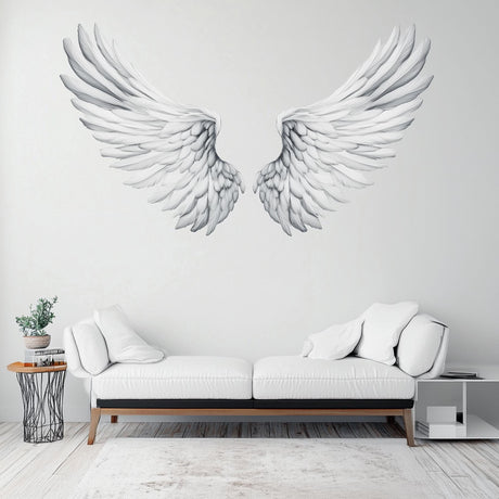 Elegant large angel wings wall decal in minimalist living room decor with white sofa.