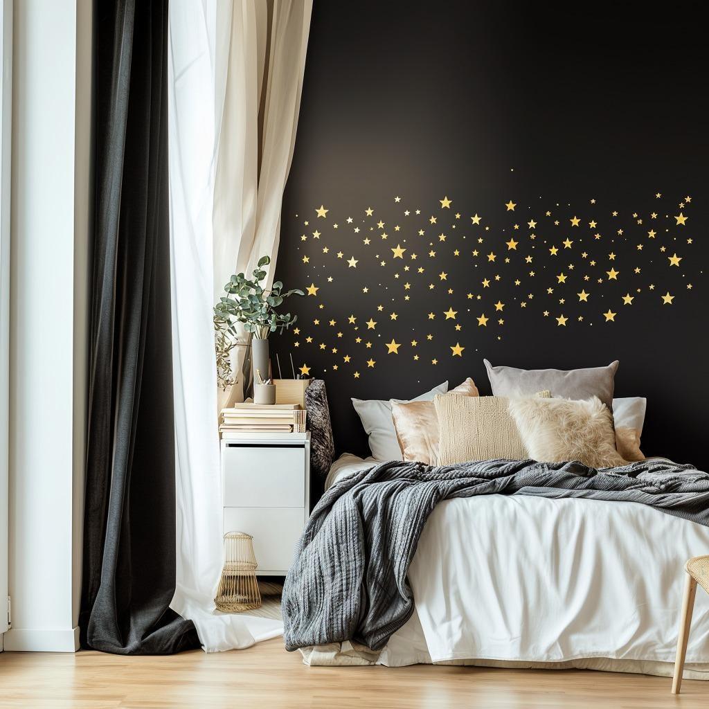 Gold stars wall decals adorning a black wall above a cozy bed, adding celestial decor to a stylish bedroom.