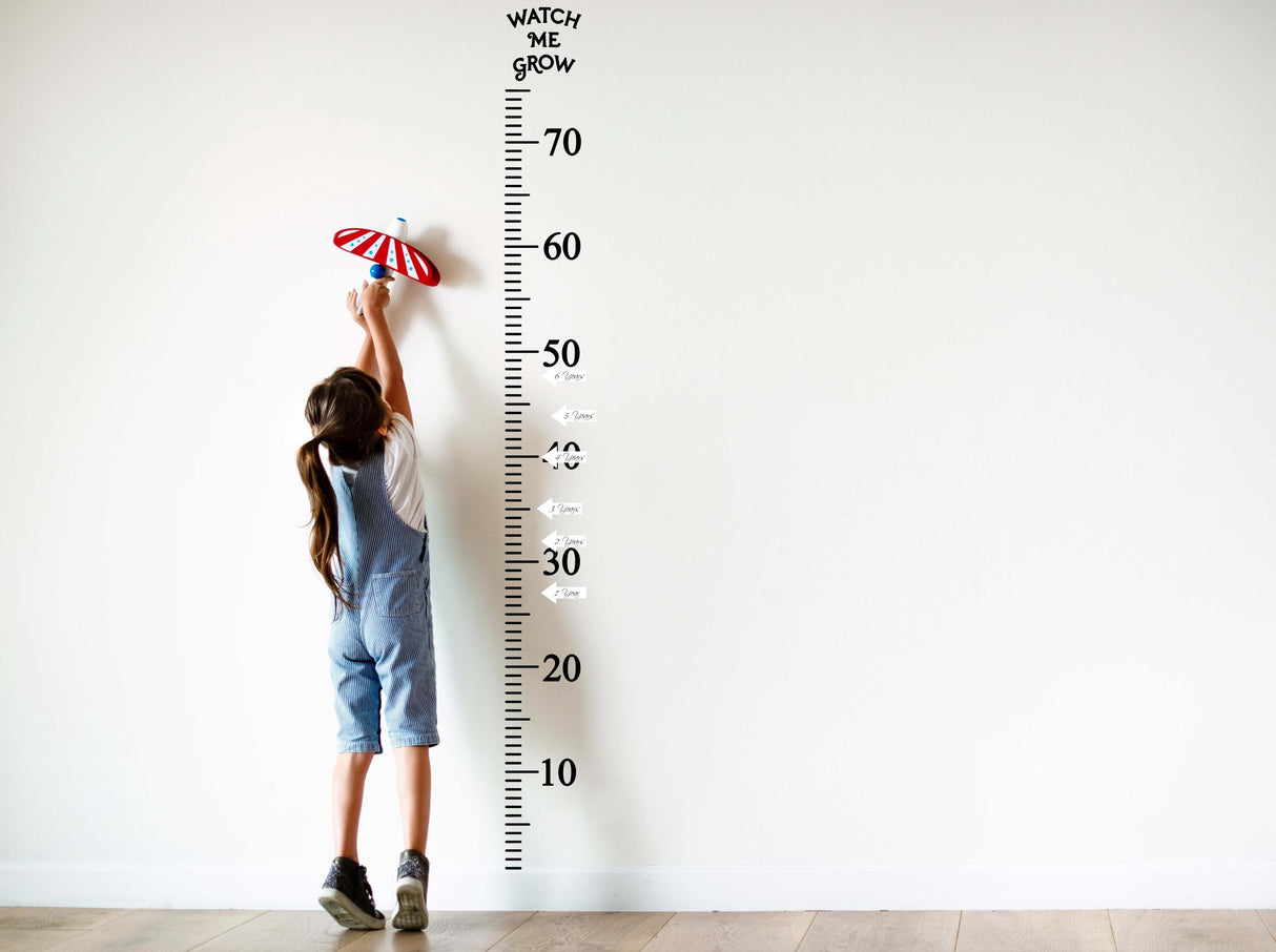 Child measuring height on a wall growth chart decal, stylish way to track growth milestones up to 70 inches.
