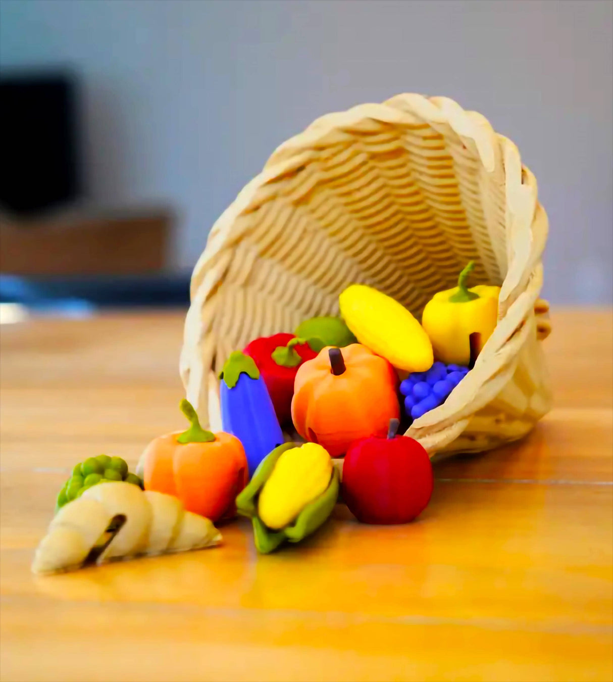 Colorful 3D-printed fall produce spilling from a wicker basket, perfect for Thanksgiving decorations.
