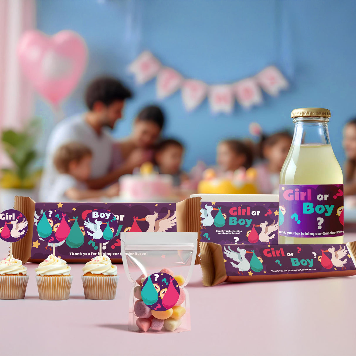 Colorful gender reveal decorations featuring stickers on cupcakes, chocolate bars, and drinks at a festive party.