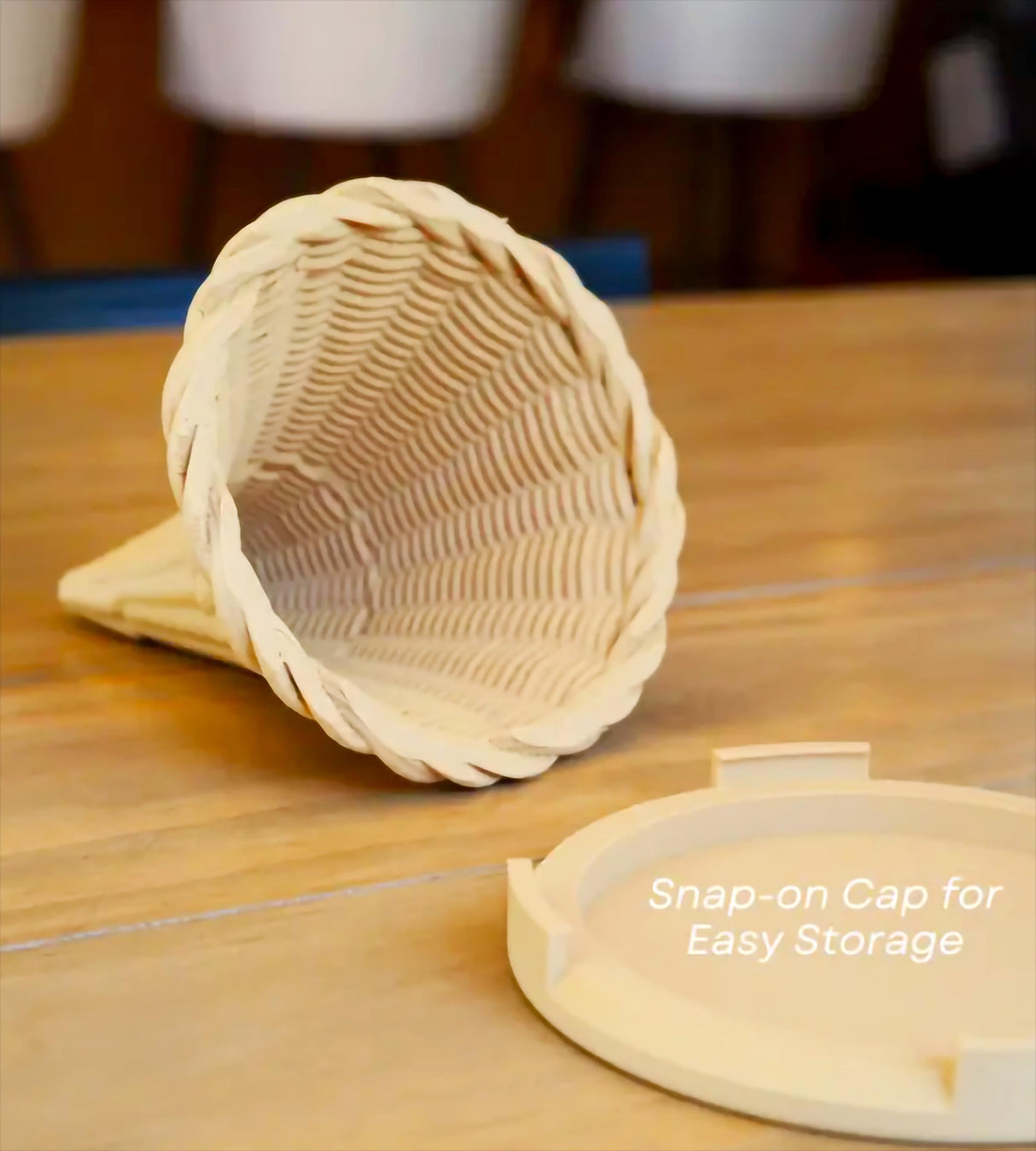 3D-printed cup holder with a snap-on cap for easy storage on a wooden table.
