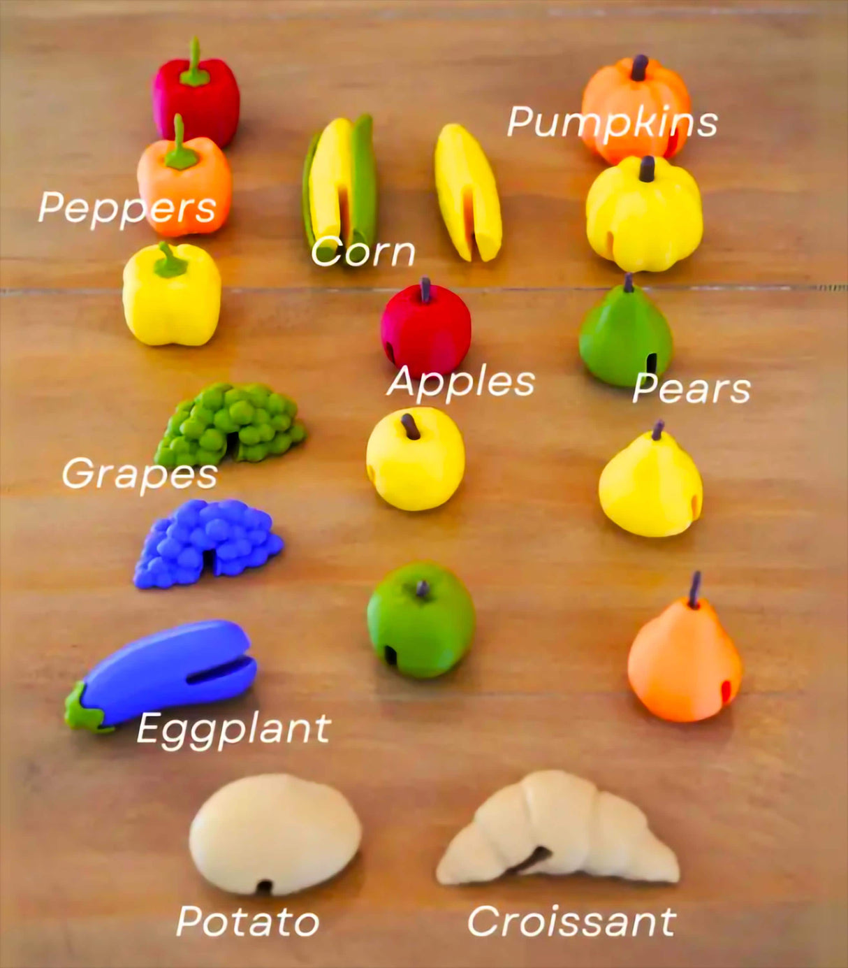 Colorful 3D-printed fall-themed drink markers shaped like fruits and vegetables for Thanksgiving celebrations.