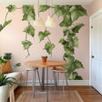 Hanging vine wall decal in a cozy dining room, featuring cascading green leaves on a light pink wall, enhancing the space.