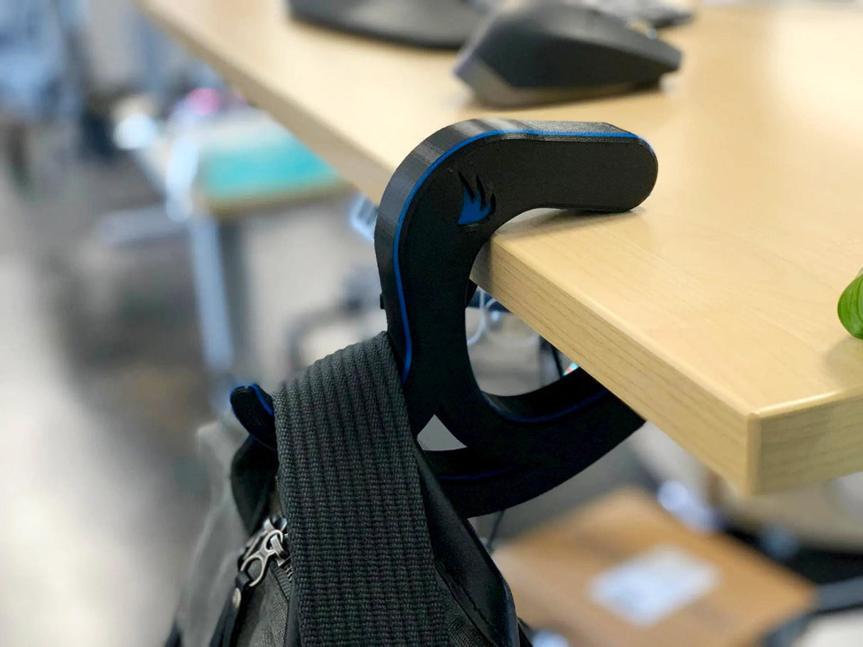 Portable desk bag hook holding a backpack, versatile accessory for keeping bags off the floor at work.