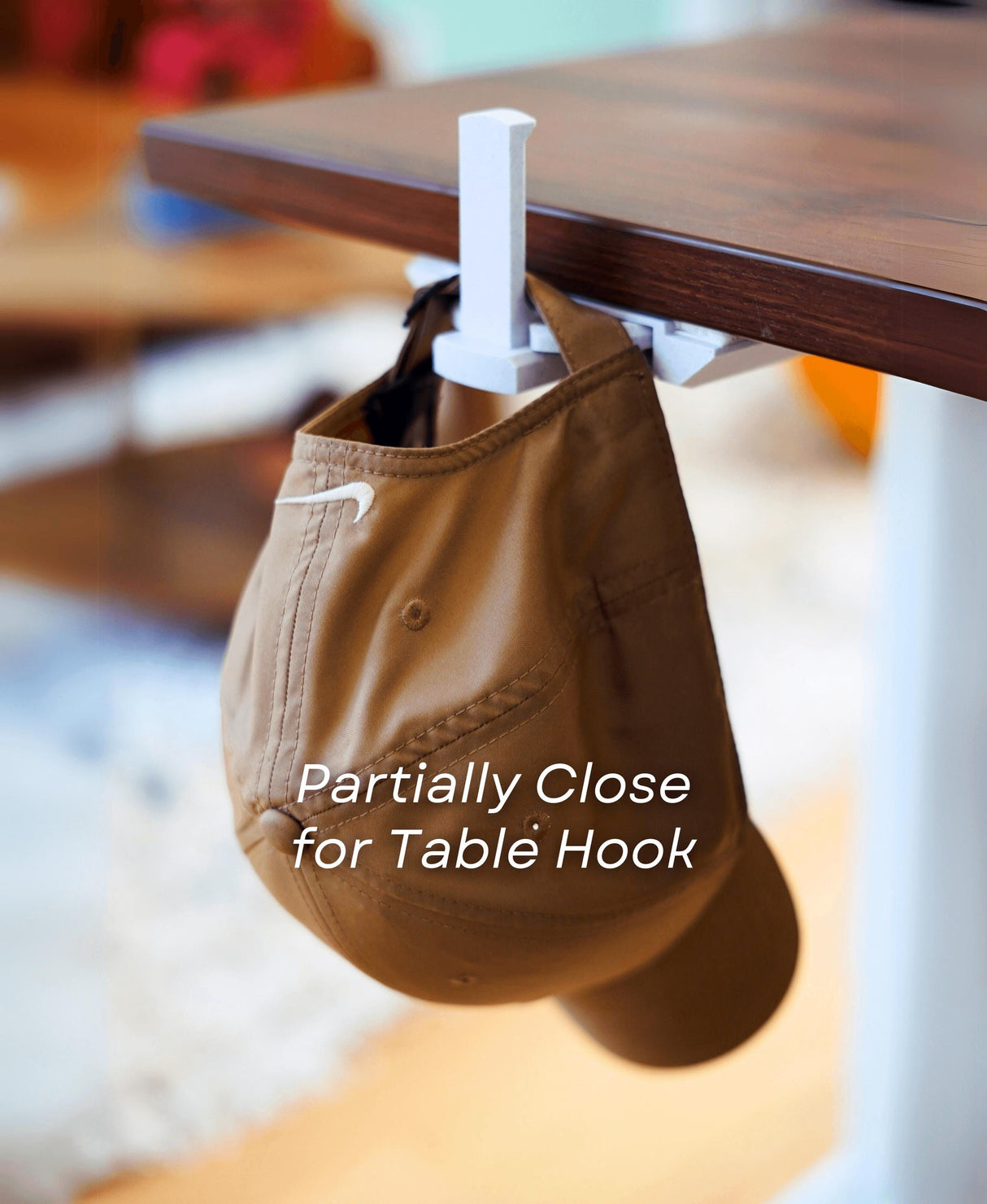 Under-desk cup holder displaying a brown hat hanging from a table hook, showcasing the minimalist design and functionality.