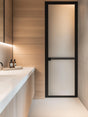 Modern bathroom featuring a frosted vinyl shower door for privacy against wooden paneling.