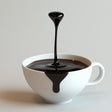 3D printed floating coffee drop sculpture in a white cup, showcasing an optical illusion of coffee dripping.