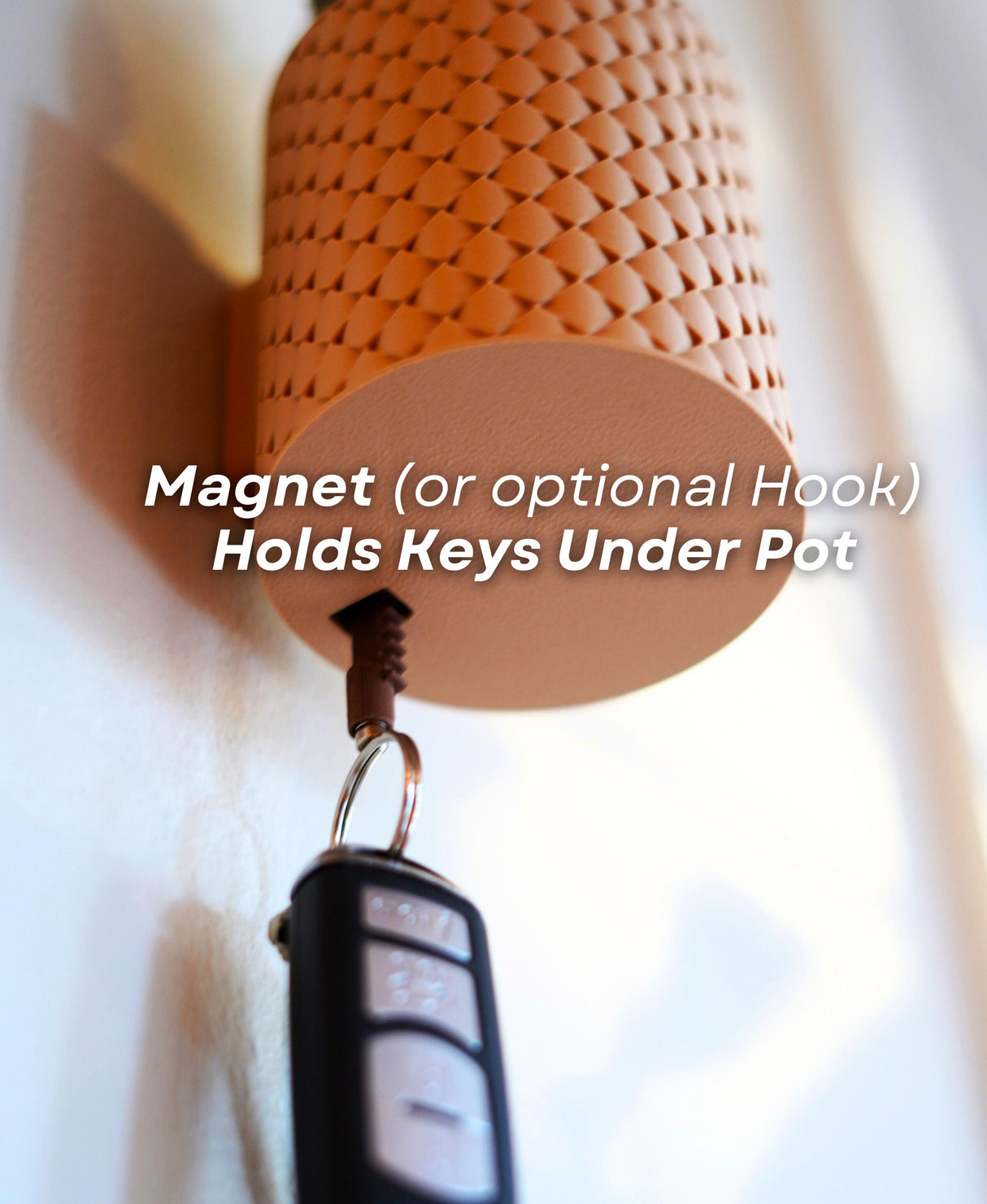 Close-up of a pot with a magnet holding keys underneath, showcasing a unique key storage solution.