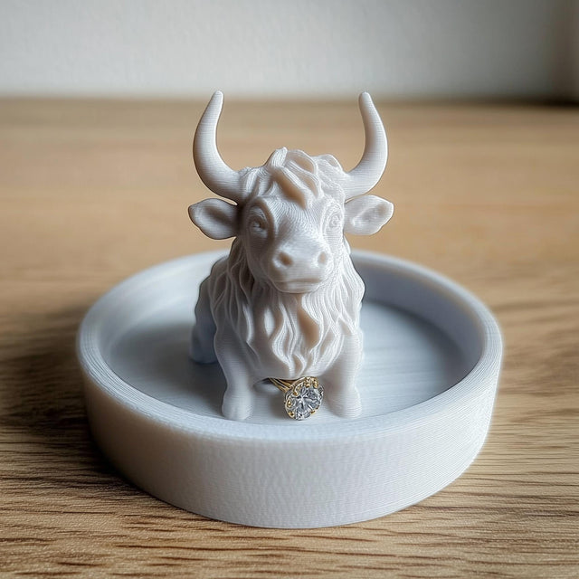 3D-printed Highland cow jewelry dish with a ring, rustic trinket tray for jewelry organization.