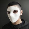 White matte full face mask worn by a person with short hair, showcasing curved contours and clean eye openings.