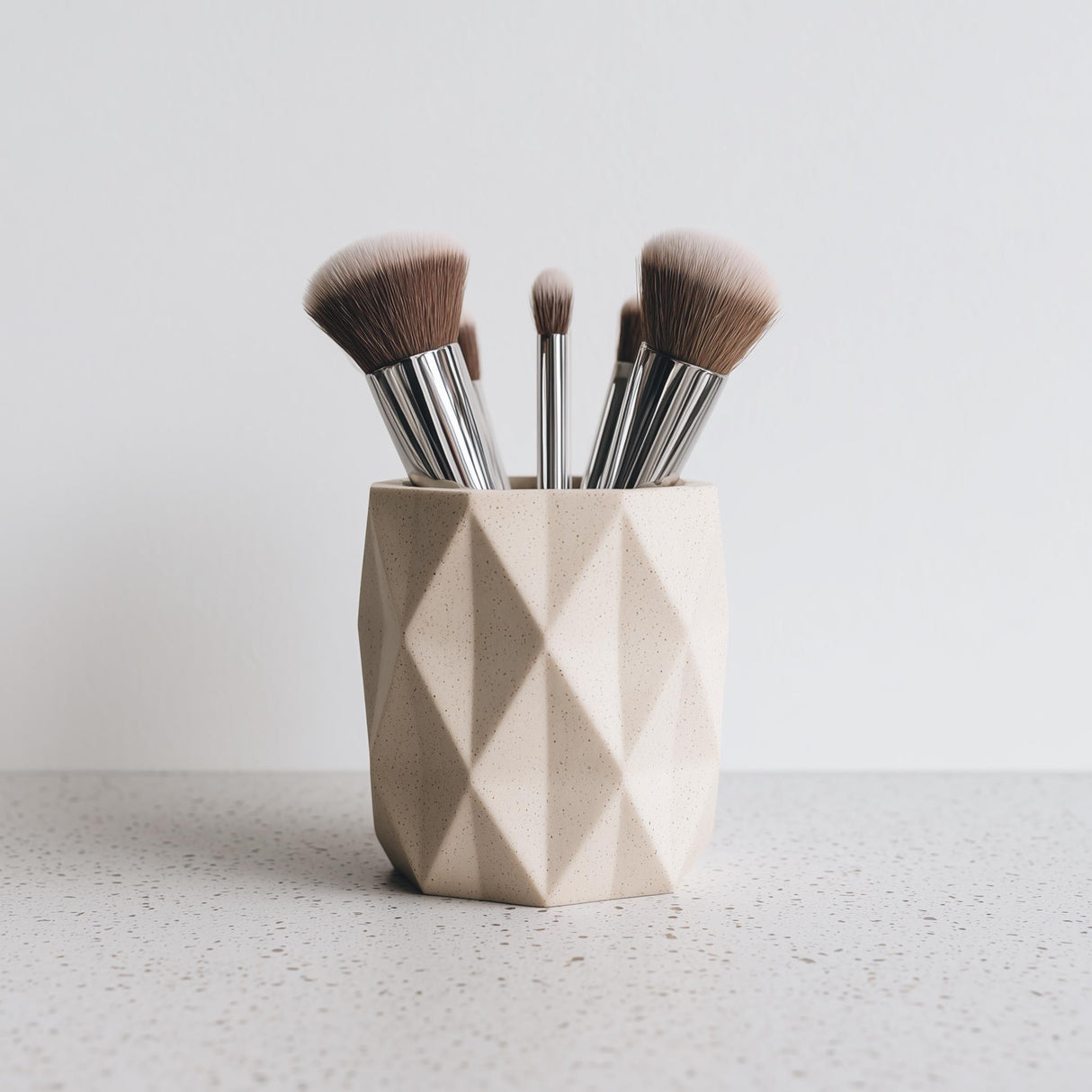 Light beige 3D printed geometric faceted holder, styled with makeup brushes for illustration; brushes are not included.