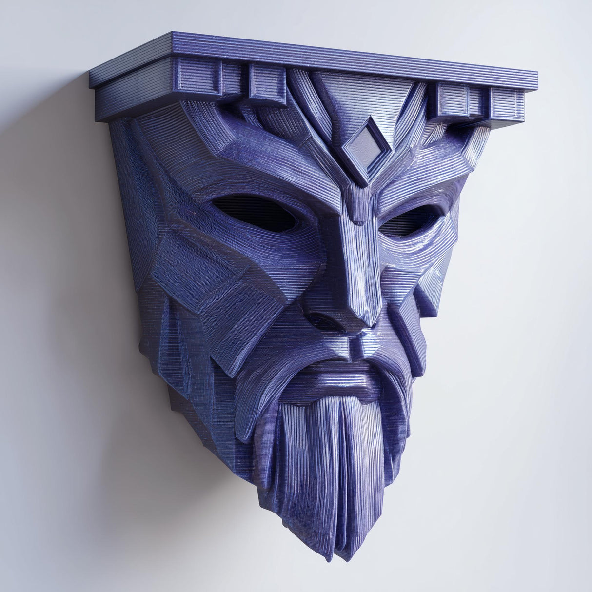 3D printed matte PLA wall shelf with an angular fantasy guardian mask face supporting a small display ledge on a light wall.
