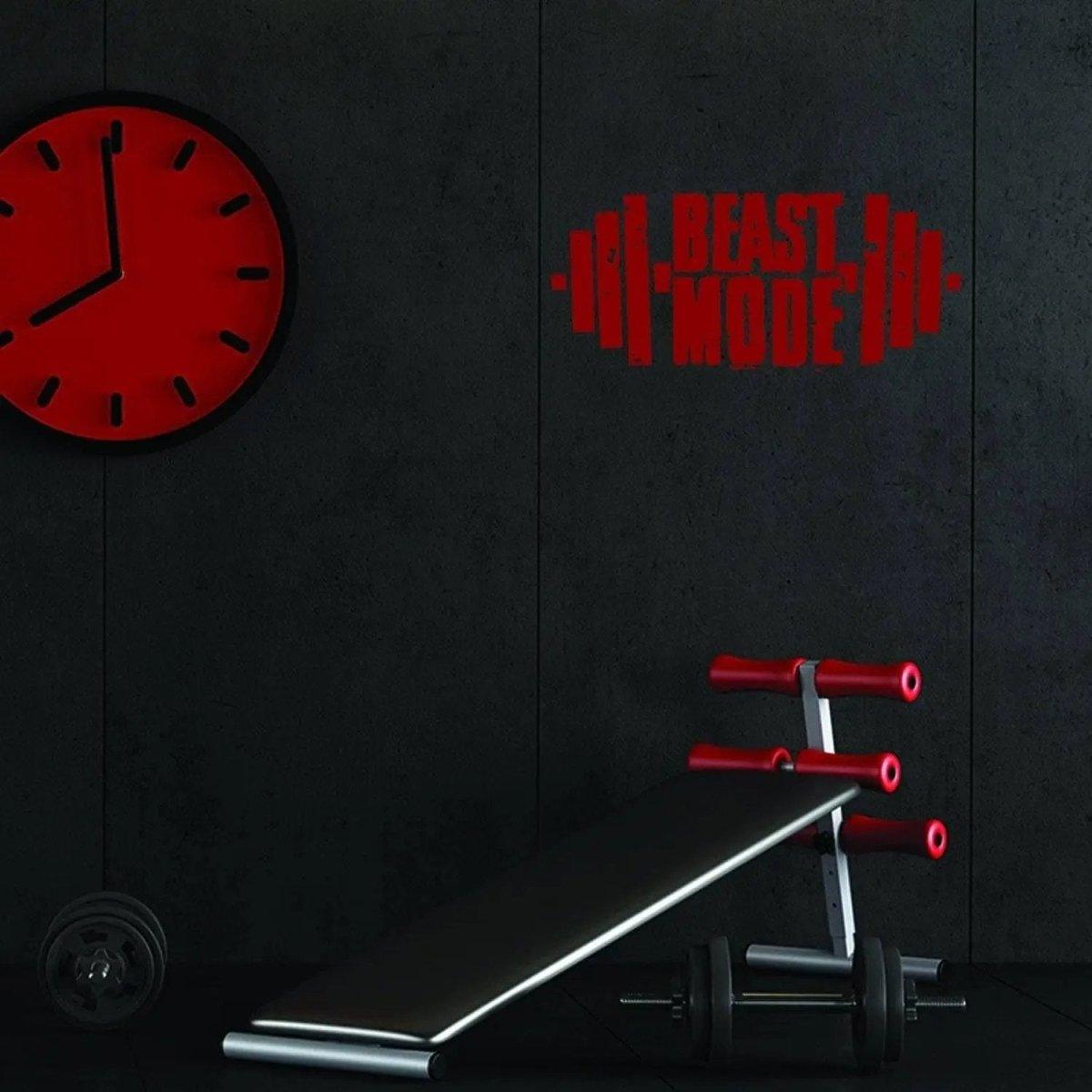 Inspiring gym wall decal reading 'BEAST MODE' above workout bench with weights and wall clock.