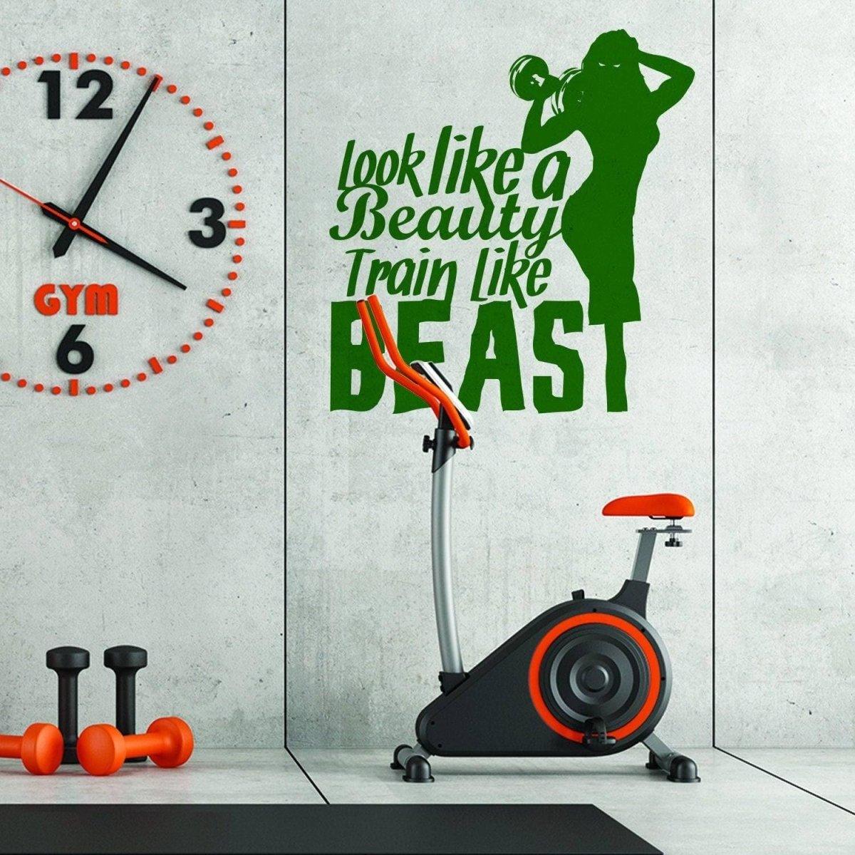 Motivational wall sticker 'Look like a Beauty, Train like a BEAST' in gym with exercise bike.