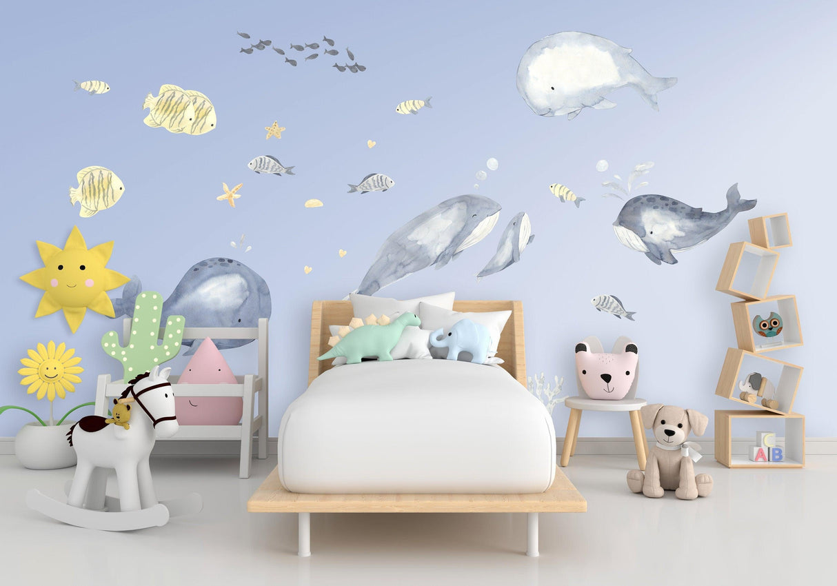 Vibrant undersea themed wall decals of whales and fish in a child's bedroom, creating a charming ocean-inspired decor.