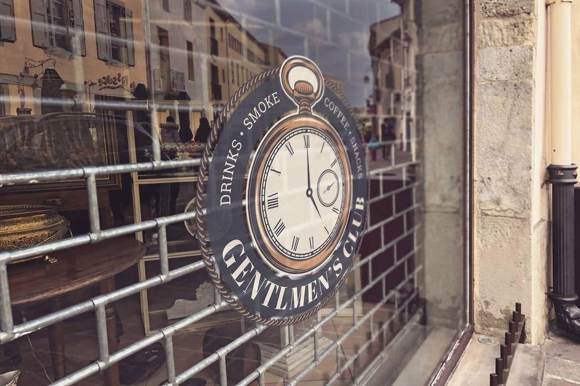 Vintage clock sign for a Gentlemen's Club, showcasing drinks, smoke, and comfort features.