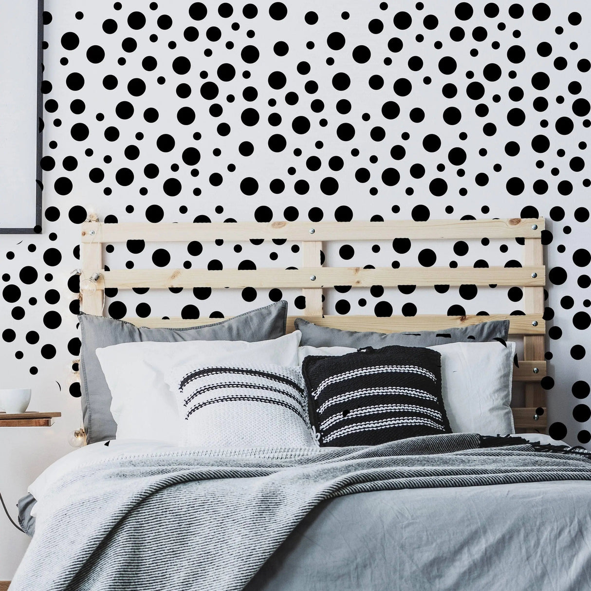 Vinyl circle wall decals in black on a white wall, creating a playful atmosphere in a cozy bedroom.